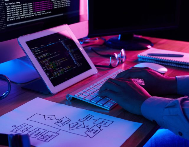 Close-up image of programmer working at his desk in office